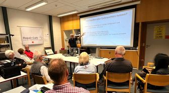 Foto: Workshop mit Teilnehmenden, Vortrag mit Beamer-Leinwand, 'Haus Einstein'