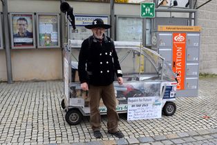 Michel vor seinem Vollkabinenfahrrad am Marktplatz